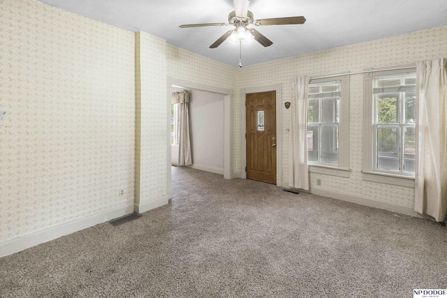 1373 S St, Blair, NE 68008 - empty room featuring wallpapered walls, carpet, ceiling fan, and healthy amount of natural light