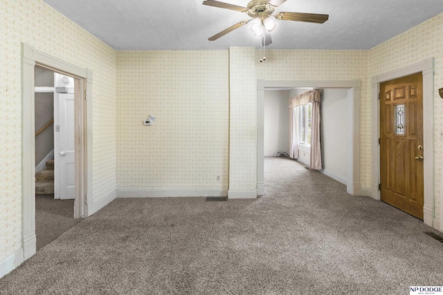 1373 S St, Blair, NE 68008 - carpeted empty room featuring a ceiling fan, wallpapered walls, stairway, and baseboards