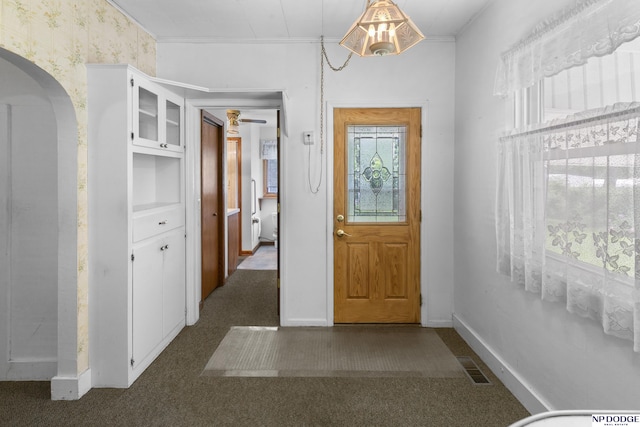 1373 S St, Blair, NE 68008 - entrance foyer featuring baseboards, arched walkways, wallpapered walls, and dark carpet