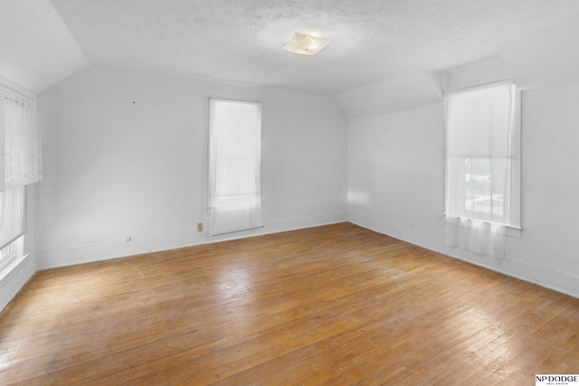 1373 S St, Blair, NE 68008 - bonus room with vaulted ceiling, light wood finished floors, baseboards, and a textured ceiling