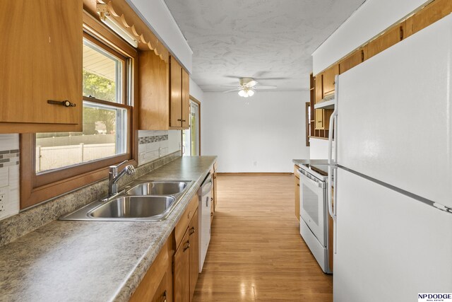 9607 Spencer St, Omaha, NE 68134 - kitchen with white appliances, under cabinet range hood, a sink, a ceiling fan, and brown cabinetry