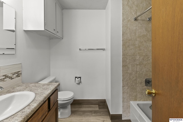 9607 Spencer St, Omaha, NE 68134 - bathroom with vanity, wood finished floors, toilet, shower / tub combination, and decorative backsplash