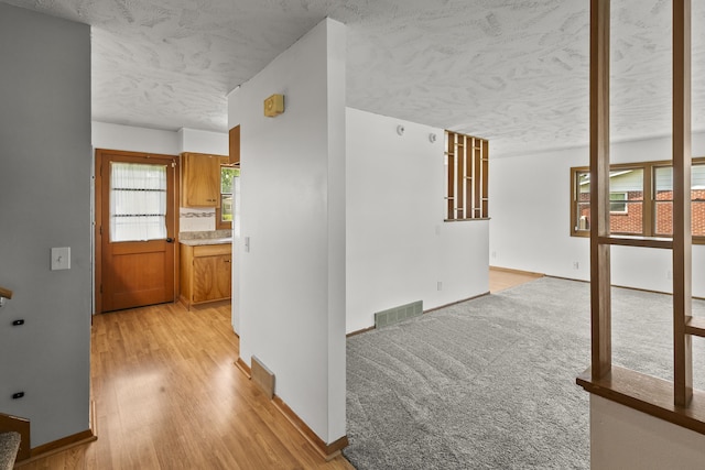 9607 Spencer St, Omaha, NE 68134 - corridor featuring a textured ceiling, light wood-style flooring, and baseboards