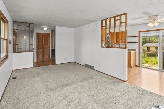 9607 Spencer St, Omaha, NE 68134 - unfurnished living room with carpet flooring, baseboards, a ceiling fan, and a textured ceiling