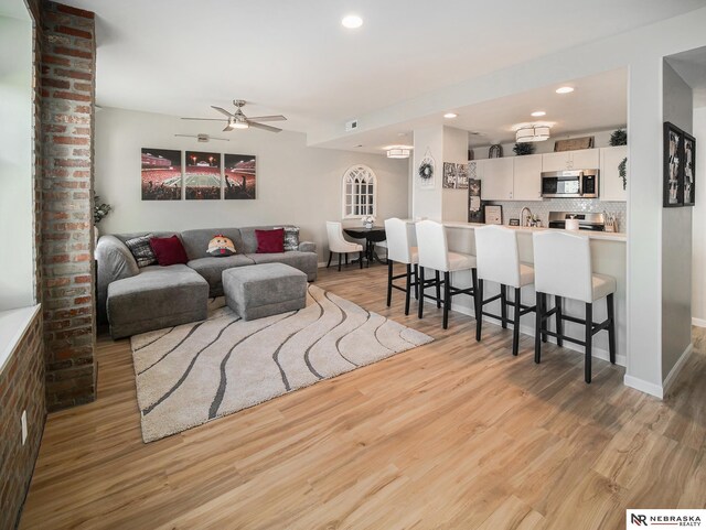 139 N 11th St Unit 905, Lincoln, NE 68508 - living area featuring a ceiling fan, light wood-style flooring, recessed lighting, baseboards, and bar area