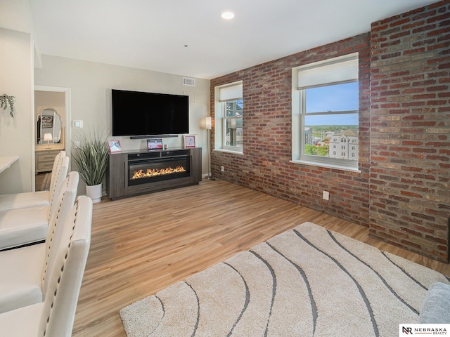 139 N 11th St Unit 905, Lincoln, NE 68508 - living area with brick wall, light wood-type flooring, and a glass covered fireplace