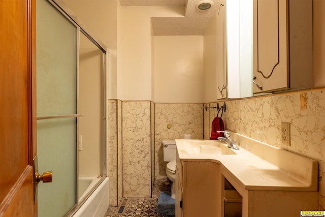 102 Eldon St, Talmage, NE 68448 - bathroom featuring toilet, vanity, enclosed tub / shower combo, wainscoting, and tile patterned flooring