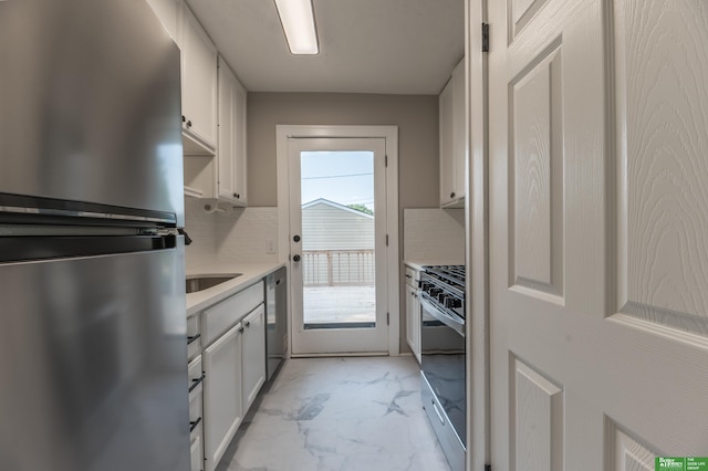 5515 Hickory St, Omaha, NE 68106 - kitchen featuring stainless steel appliances, light marble finish floors, tasteful backsplash, light countertops, and white cabinetry