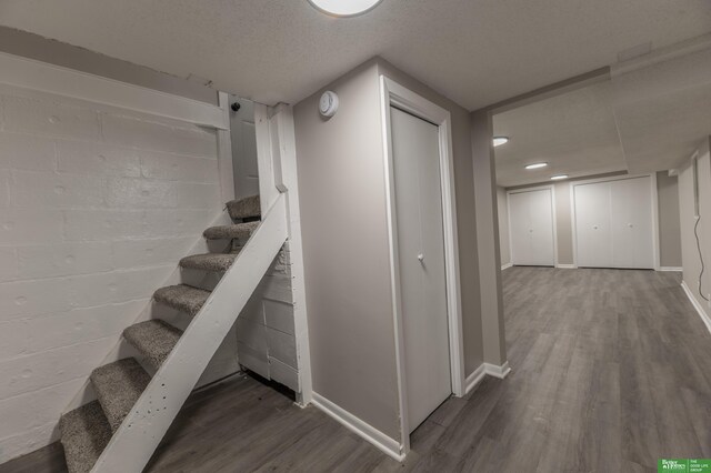 5515 Hickory St, Omaha, NE 68106 - finished basement with wood finished floors, stairway, baseboards, and a textured ceiling