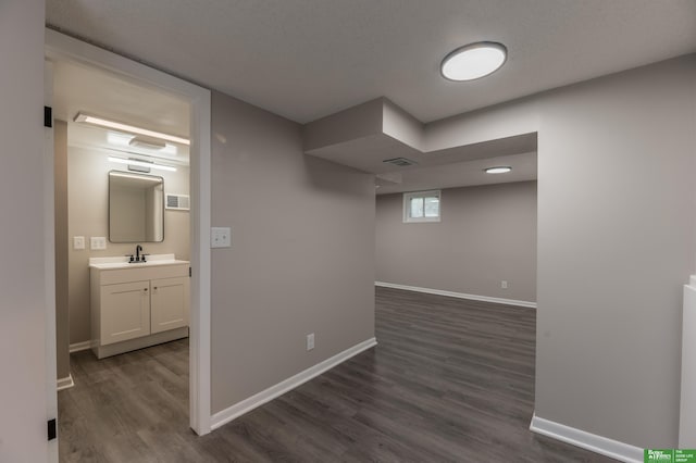 5515 Hickory St, Omaha, NE 68106 - below grade area featuring dark wood-style floors, baseboards, and a sink