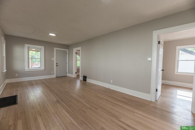 5515 Hickory St, Omaha, NE 68106 - unfurnished living room featuring light wood finished floors, healthy amount of natural light, and baseboards