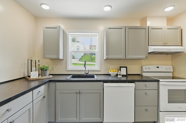 3847 Valley St, Omaha, NE 68105 - kitchen with white appliances, under cabinet range hood, dark countertops, and gray cabinetry