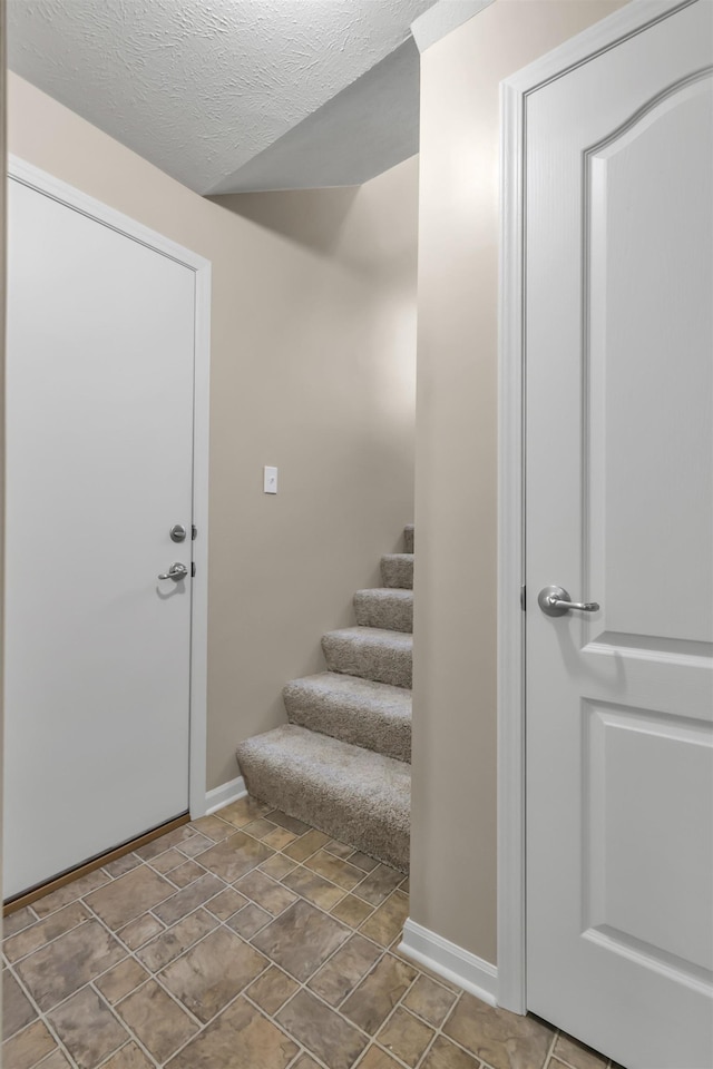 16421 Redman Ave, Omaha, NE 68116 - entrance foyer with baseboards, stairway, and a textured ceiling