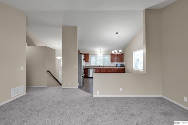 16421 Redman Ave, Omaha, NE 68116 - kitchen with appliances with stainless steel finishes, dark colored carpet, vaulted ceiling, open floor plan, and hanging light fixtures