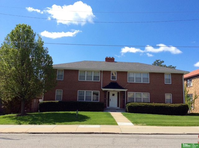 3855 Dewey Ave, Omaha, NE 68105 - view of front facade with a front yard, brick siding, and a chimney