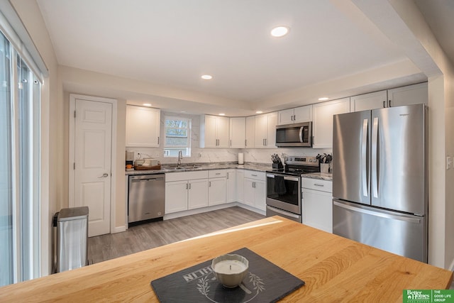601 5th Ave, Plattsmouth, NE 68048 - kitchen with stainless steel appliances, a sink, light wood-style flooring, white cabinetry, and recessed lighting