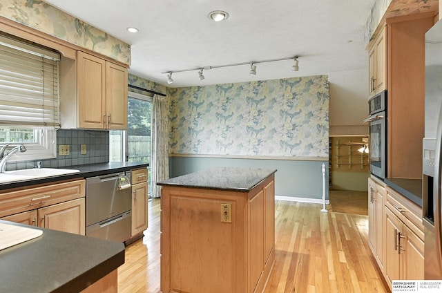 3629 S 114th Ave, Omaha, NE 68144 - kitchen with appliances with stainless steel finishes, wainscoting, dark countertops, a kitchen island, and wallpapered walls