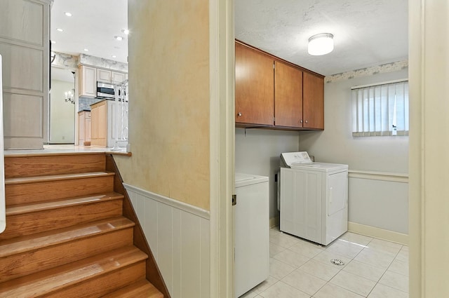 3629 S 114th Ave, Omaha, NE 68144 - laundry room with washing machine and dryer, light tile patterned floors, cabinet space, and wainscoting