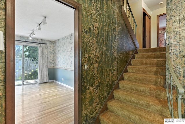 3629 S 114th Ave, Omaha, NE 68144 - staircase with wallpapered walls, wood finished floors, and track lighting