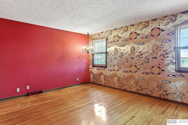 3629 S 114th Ave, Omaha, NE 68144 - spare room with wallpapered walls, a textured ceiling, wood finished floors, and healthy amount of natural light