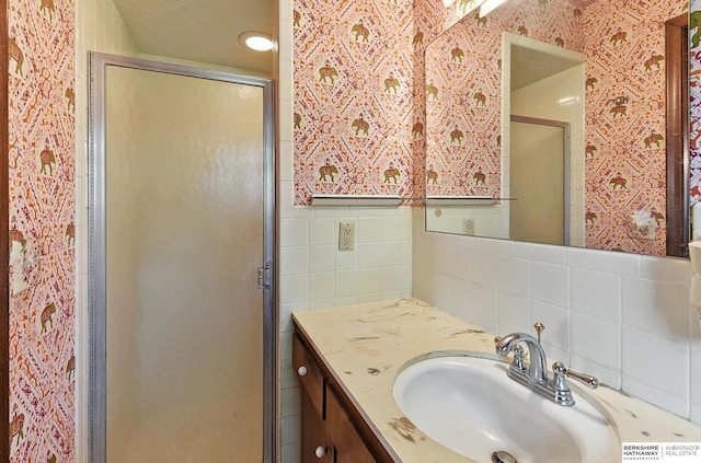 3629 S 114th Ave, Omaha, NE 68144 - bathroom featuring a shower stall, vanity, tile walls, wallpapered walls, and tasteful backsplash