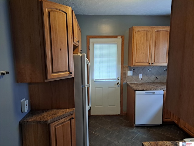 1519 Washington St, Lincoln, NE 68502 - kitchen with white appliances, dark countertops, and backsplash