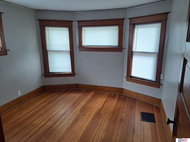 1519 Washington St, Lincoln, NE 68502 - spare room featuring wood-type flooring, baseboards, and ornamental molding