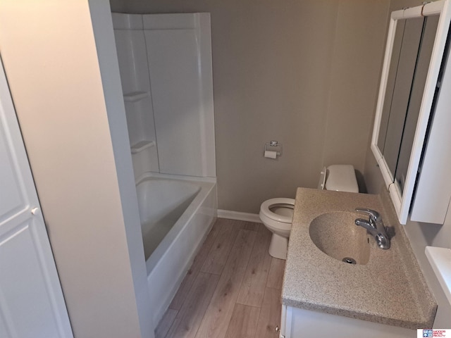 1519 Washington St, Lincoln, NE 68502 - full bath with toilet, baseboards, vanity, wood finished floors, and shower / washtub combination
