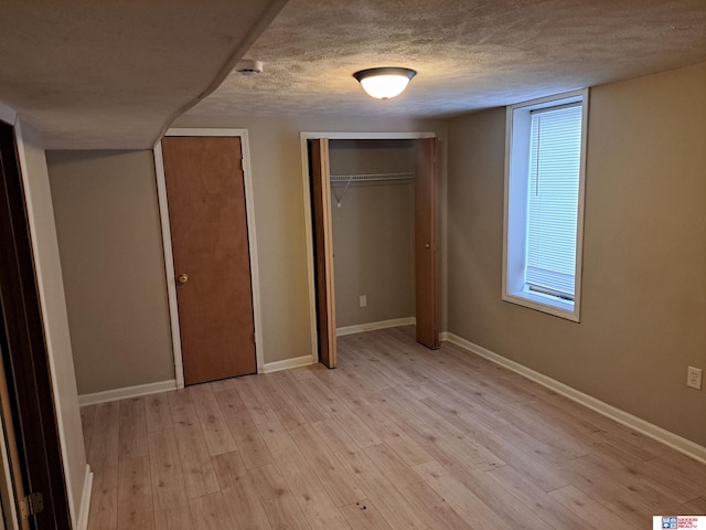 1519 Washington St, Lincoln, NE 68502 - unfurnished bedroom with light wood-style floors, a textured ceiling, baseboards, and multiple closets