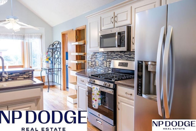 611 Diamond Ln, Papillion, NE 68133 - kitchen featuring stainless steel appliances, a sink, a ceiling fan, dark countertops, and tasteful backsplash
