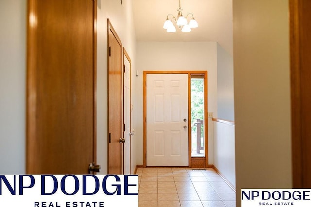 611 Diamond Ln, Papillion, NE 68133 - foyer entrance with a chandelier, light tile patterned flooring, and baseboards