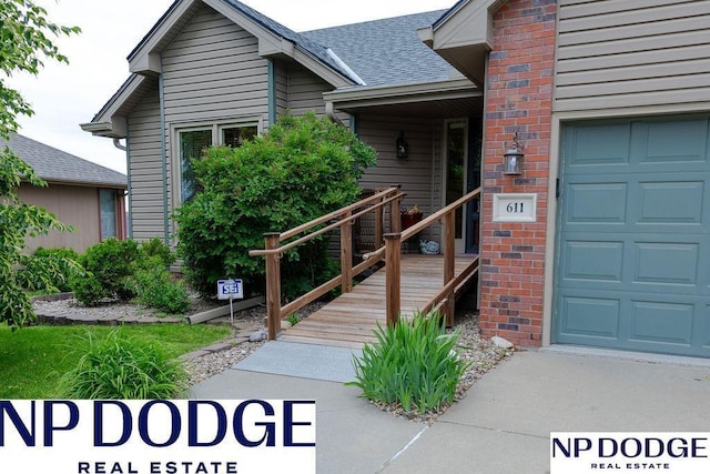 611 Diamond Ln, Papillion, NE 68133 - doorway to property with roof with shingles, a garage, and brick siding