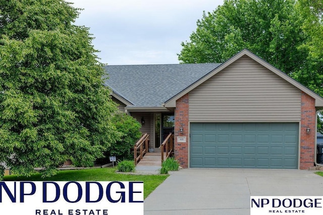 611 Diamond Ln, Papillion, NE 68133 - view of front of home with brick siding, an attached garage, driveway, and roof with shingles