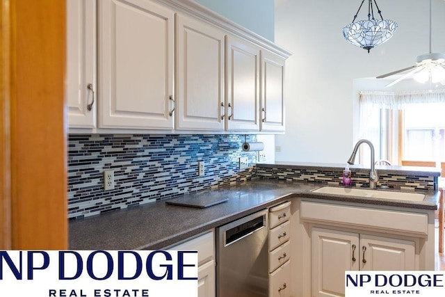 611 Diamond Ln, Papillion, NE 68133 - kitchen with dishwasher, a sink, tasteful backsplash, dark countertops, and white cabinetry
