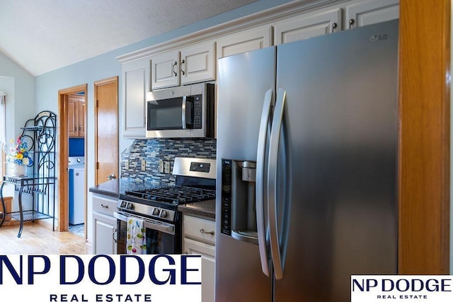 611 Diamond Ln, Papillion, NE 68133 - kitchen with appliances with stainless steel finishes, dark countertops, backsplash, and vaulted ceiling