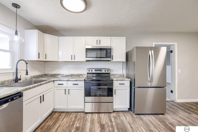 1801 Elk St, Beatrice, NE 68310 - kitchen with stainless steel appliances, a sink, light wood-style floors, and white cabinetry