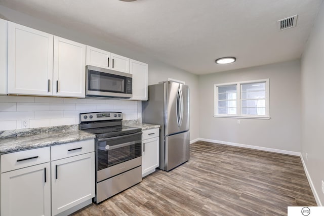 1801 Elk St, Beatrice, NE 68310 - kitchen featuring appliances with stainless steel finishes, baseboards, backsplash, and white cabinets