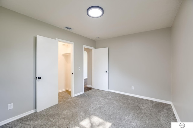 1801 Elk St, Beatrice, NE 68310 - unfurnished bedroom with carpet floors, a walk in closet, and baseboards