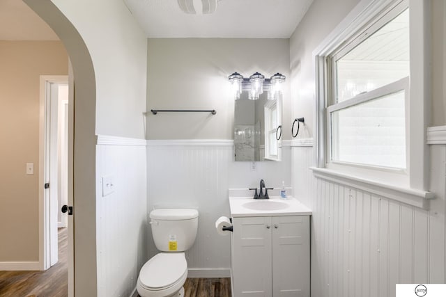 1801 Elk St, Beatrice, NE 68310 - bathroom with a wainscoted wall, vanity, toilet, and wood finished floors