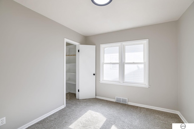 1801 Elk St, Beatrice, NE 68310 - unfurnished bedroom featuring carpet, a spacious closet, baseboards, and a closet