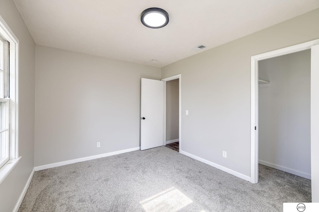 1801 Elk St, Beatrice, NE 68310 - unfurnished bedroom featuring carpet flooring, a spacious closet, and baseboards