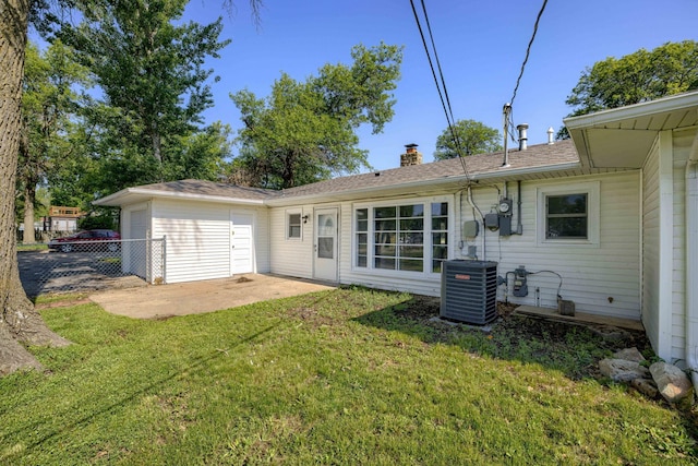 1801 Elk St, Beatrice, NE 68310 - rear view of property with central AC unit, a patio, a chimney, and a garage