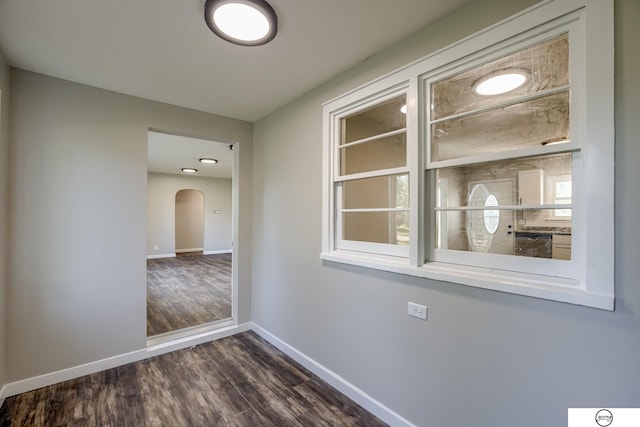 1801 Elk St, Beatrice, NE 68310 - corridor with baseboards, dark wood finished floors, and arched walkways