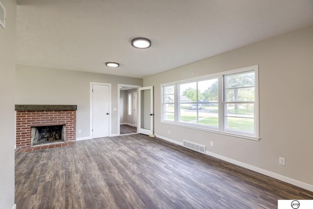 1801 Elk St, Beatrice, NE 68310 - unfurnished living room with dark wood-style floors, baseboards, and a brick fireplace