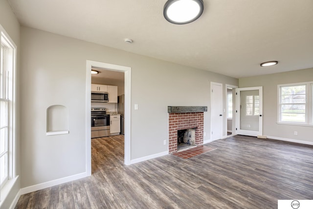1801 Elk St, Beatrice, NE 68310 - unfurnished living room with dark wood-style flooring and baseboards