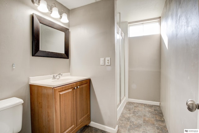 6205 Nebraska Ave, Omaha, NE 68104 - bathroom featuring toilet, vanity, an enclosed shower, baseboards, and stone finish flooring