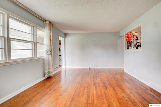 6205 Nebraska Ave, Omaha, NE 68104 - spare room with wood-type flooring, a textured ceiling, and baseboards