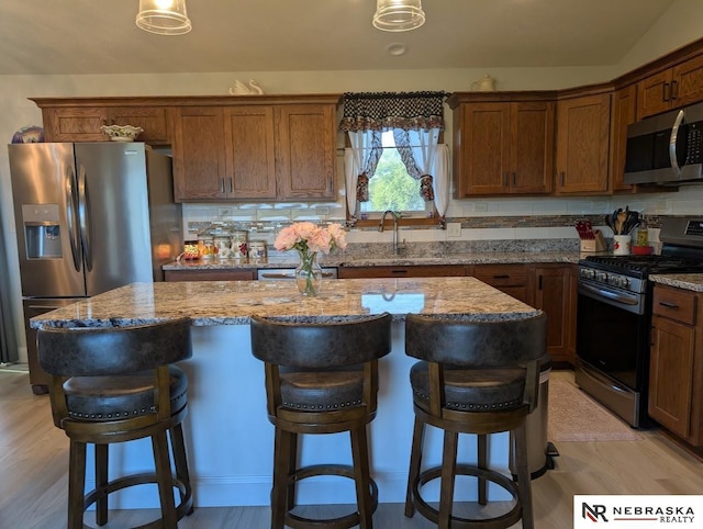 2496 Rock Creek Rd, Bee, NE 68314 - kitchen featuring appliances with stainless steel finishes, a sink, a kitchen island, and light stone counters