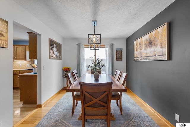 17205 Jessica Ln, Gretna, NE 68028 - dining area featuring light wood-style floors, a textured ceiling, and a chandelier