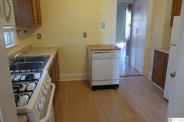 2722 N 64th St, Omaha, NE 68104 - kitchen with white appliances, a sink, light wood finished floors, and brown cabinetry